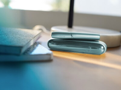 IQOS ORIGINALS DUO turquoise sur une table.